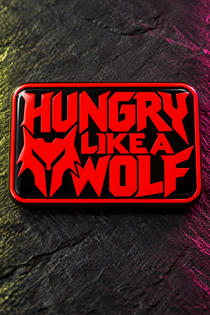 A rectangular black plaque or sign with a red border and bold red text reading “HUNGRY LIKE A WOLF,” photographed on a dark textured surface with colored lighting.
